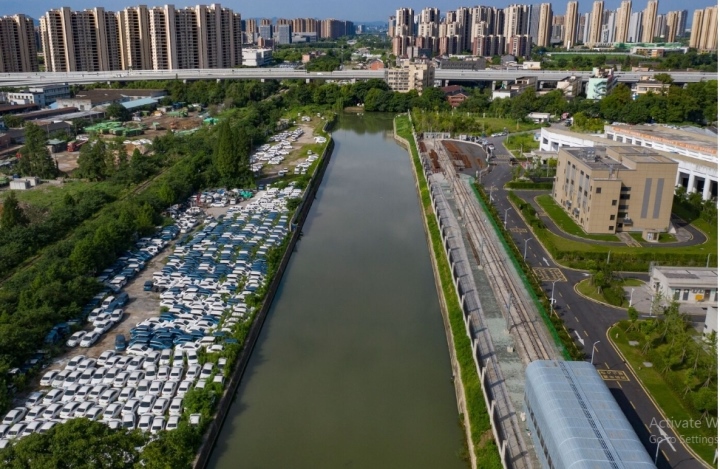 Tại một địa điểm khác, gần một con sông và dọc theo đường xe điện vắng vẻ, khoảng 1.000 chiếc xe điện bám đầy bụi. (Ảnh: Qilai Shen/Bloomberg)