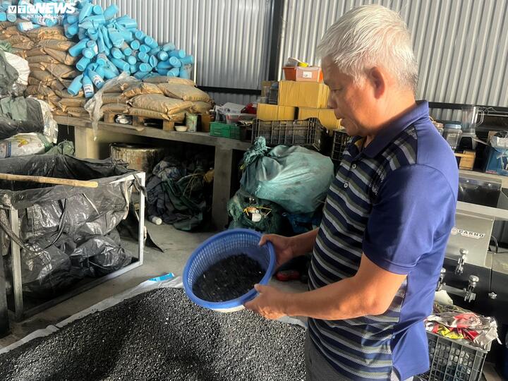 Trên tay ông Xuân là rác thải nhựa đã qua khâu xử lý và nghiền nát.