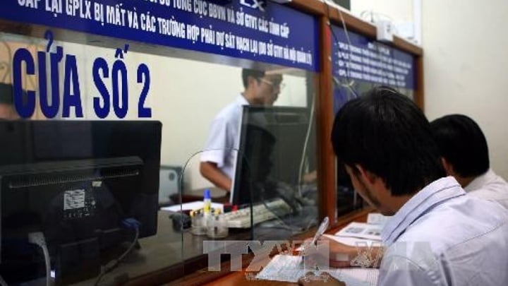 Người dân làm thủ tục đăng ký xe tại quận Ba Đình, Hà Nội. Ảnh: Huy Hùng/TTXVN