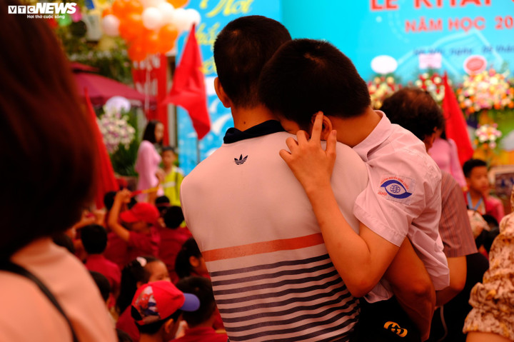 Một phụ huynh bế con đến trường, ai nhìn hình ảnh này cũng đều rưng rưng cảm xúc.