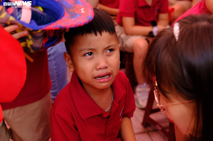 Một học sinh òa khóc nức nở giữa sân trường. Cô giáo âu yếm dỗ dành, giúp em lấy lại bình tĩnh.