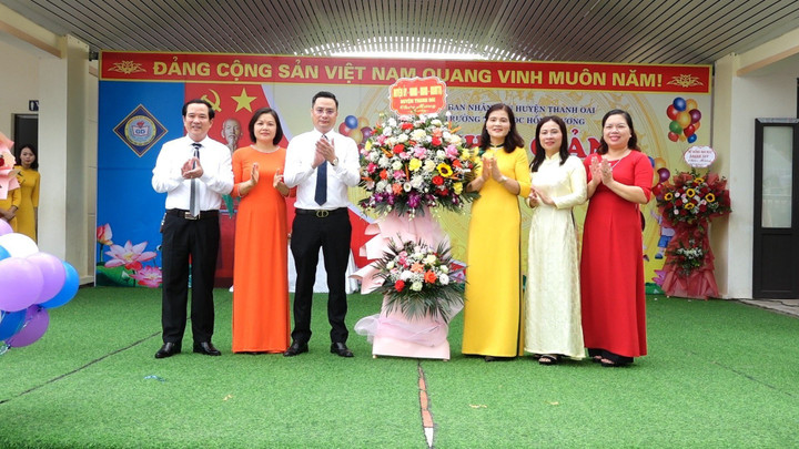Ông Bùi Văn Sáng - Chủ tịch UBND huyện Thanh Oai (đứng thứ 3 từ trái sang) tặng hoa chúc mừng nhà trường nhân dịp khai giảng năm học mới 2023-2024.
