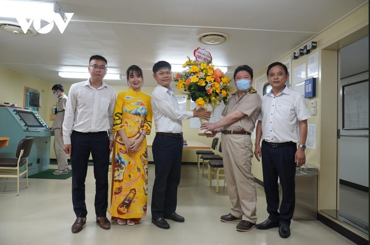 Ông Trần Lê Tuấn, Tổng Giám đốc Cảng Đà Nẵng (áo trắng giữa) tặng hoa thuyền trưởng tàu WanHai 362