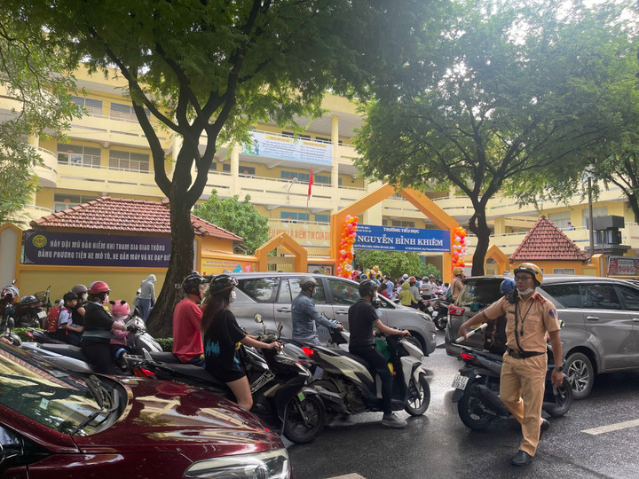 Trước cổng trường Tiểu học Nguyễn Bỉnh Khiêm (Quận 1, TP.HCM) phải nhờ đến sự phân luồng của cảnh sát giao thông. (Ảnh: Phan Nga)