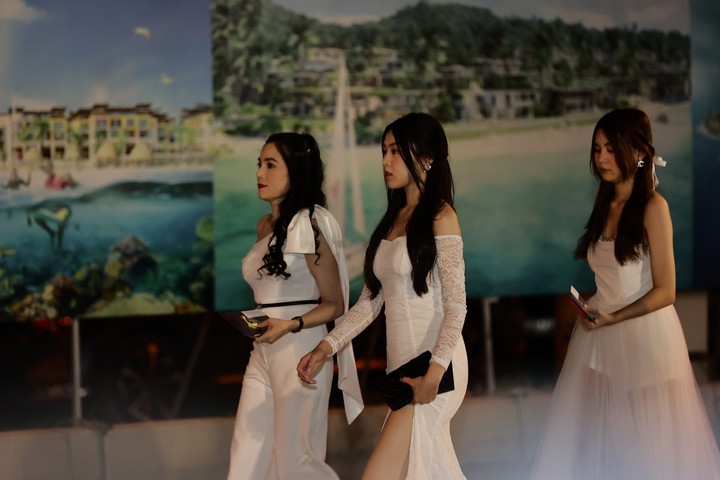 Hai cô gái diện đầm trắng cùng tông màu với bộ trang phục của mẹ, tự tin bước lên thảm đỏ của sự kiện.