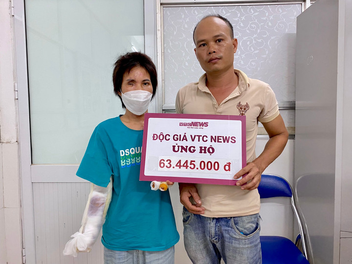 Vợ chồng chị Chanh nhận tiền ủng hộ của quý độc giả. (Ảnh: Nguyễn Ngoan)