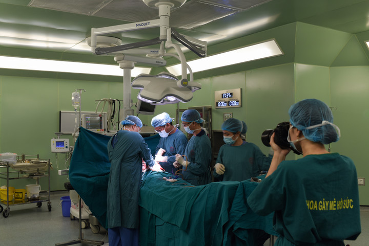 Chị Hồng tác nghiệp trong phòng phẫu thuật. (Ảnh: Nguyễn Ngoan)