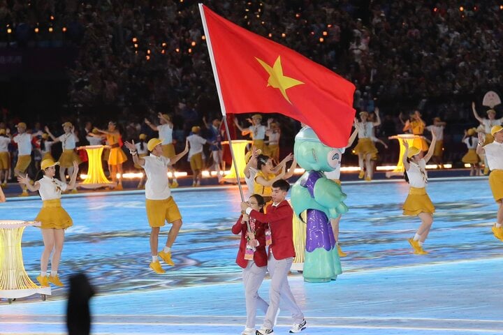 Nguyễn Huy Hoàng, Nguyễn Thị Hường rước Quốc kỳ dẫn đầu đoàn thể thao Việt Nam diễu hành. (Ảnh: Đức Thiện)