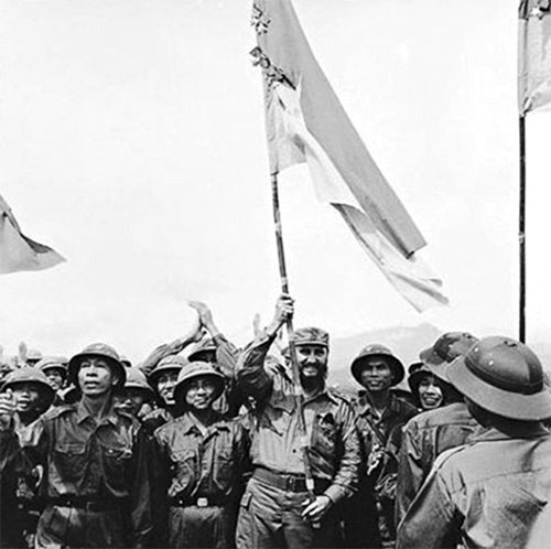 Chủ tịch Fidel Castro phất cao lá cờ bách chiến, bách thắng lấp lánh huân chương của Đoàn Khe Sanh, Quân Giải phóng Trị Thiên - Huế tại Cao điểm 241, ngày 16/9/1973. (Ảnh: TTXVN).