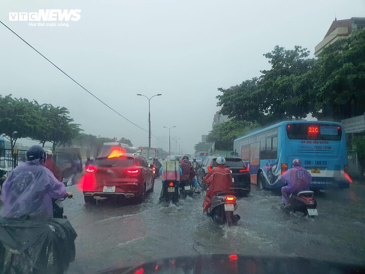 Người dân vất vả di chuyển trên đường Giải Phóng giữa trời mưa lớn, đường ngập.