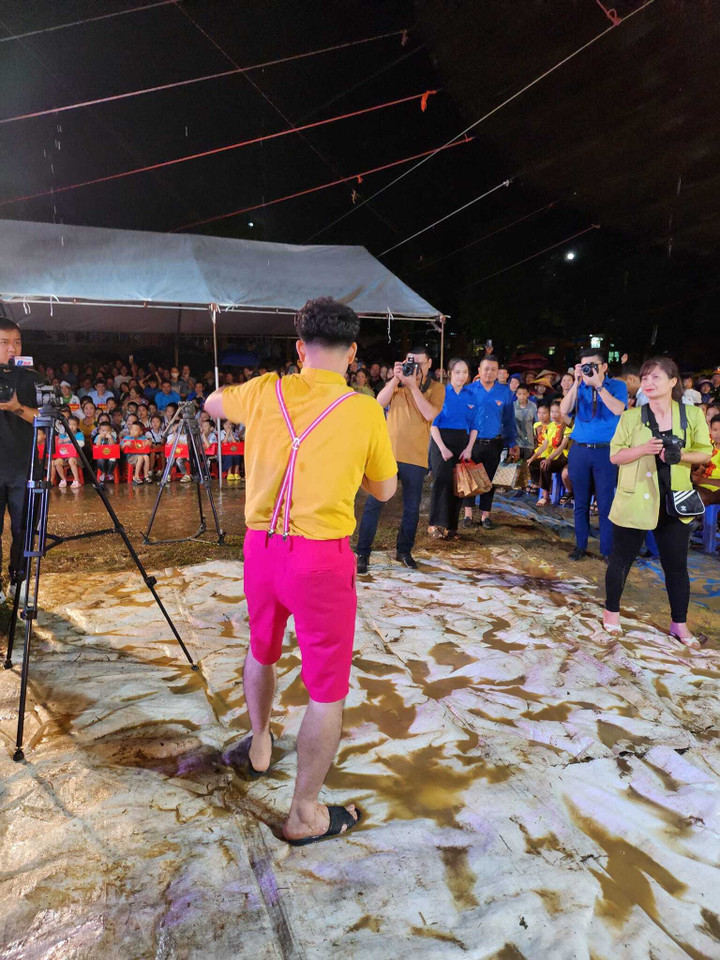 Vì mưa lớn thất thường nên khu vực biểu diễn dù đã được trải bạt dưới nền để chống trơn trượt nhưng vẫn đầy bùn đất.