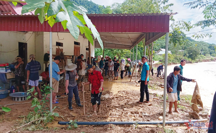 Bà con đang mở đường tạm đi qua thềm nhà của một hộ dân. (Ảnh: VT)