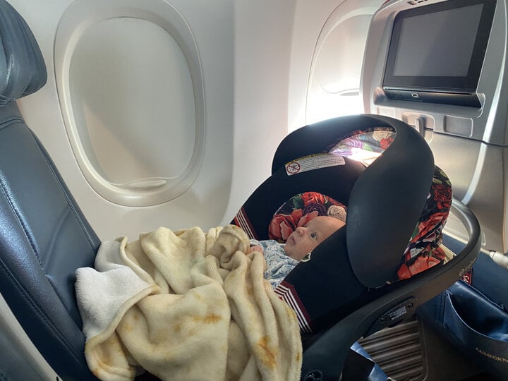 Trẻ em nên ngồi ở đâu khi đi máy bay? Cục Hàng không Liên bang Mỹ cho rằng trẻ dưới 2 tuổi nên được đặt vào ghế dành riêng cho trẻ em trên ô tô thay vì ngồi trong lòng bố mẹ. (Ảnh: Anna Everywhere)