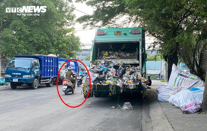 Hình ảnh Xe rác tập kết 2 bên đường, chỉ để lại khoảng nhỏ cho phương tiện khác lưu thông.