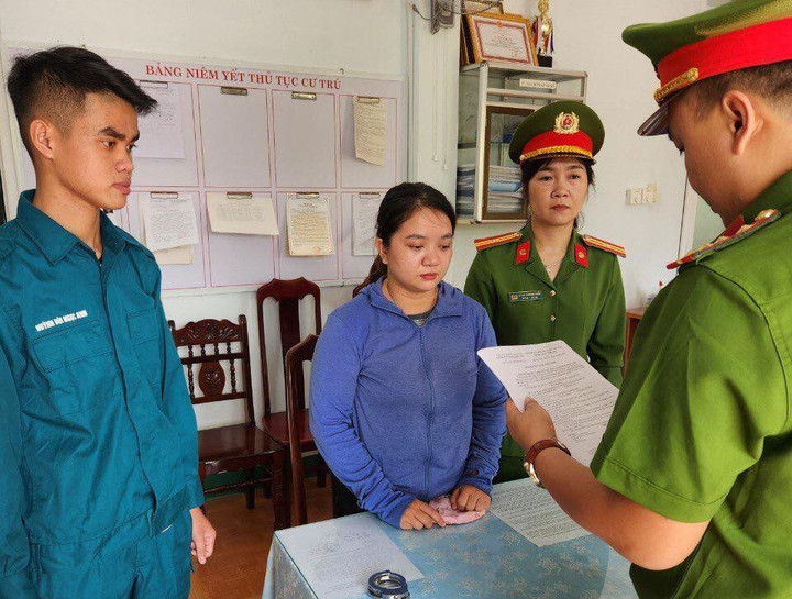 Lực lượng chức năng đọc quyết định khởi tố Nguyễn Thị Diễm My. (Ảnh: C.A)