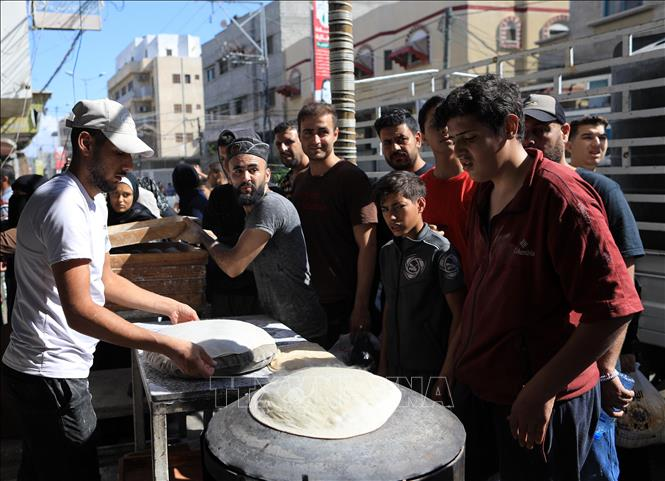 Người dân xếp hàng chờ nhận thức ăn cứu trợ tại Dải Gaza ngày 15/10/2023. (Ảnh minh họa: THX/TTXVN)