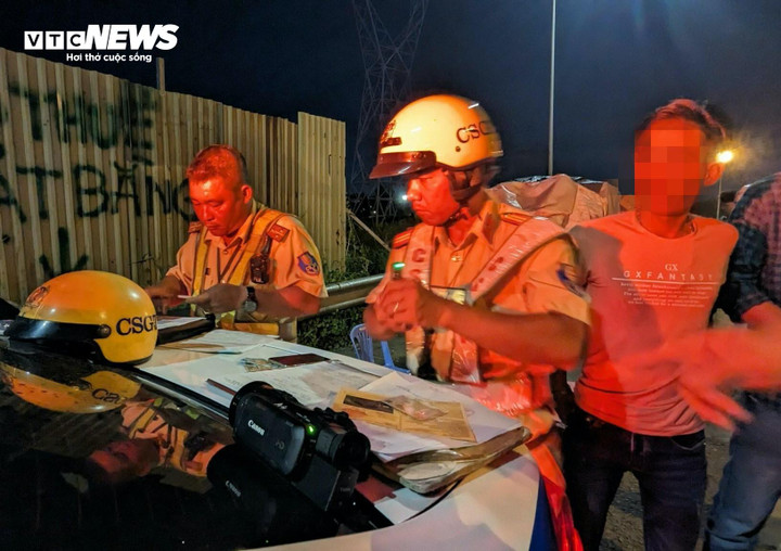 Hình ảnh lực lượng chức năng đang lập biên bản xử phạt đối với các tài xế xe khách vi phạm các quy định về vận tải hành khách.