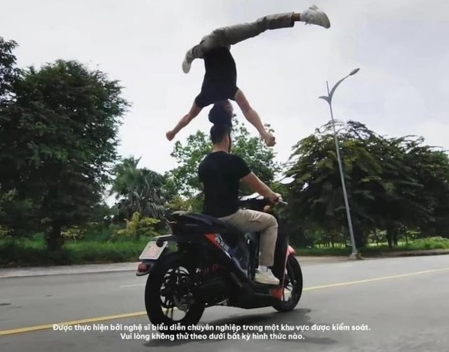 Hai anh em Quốc Cơ- Quốc Nghiệp biểu diễn chồng đầu đi xe máy. Ảnh cắt từ Clip.