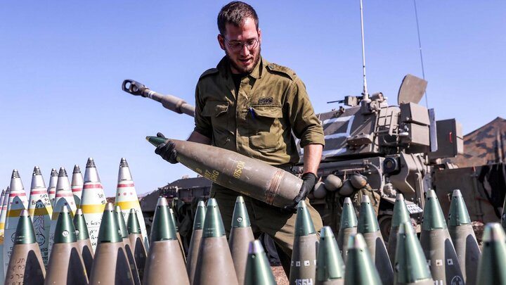 Một binh sĩ Israel mang đạn pháo 155mm cho pháo tự hành được triển khai gần biên giới với Lebanon ở miền bắc Israel, ngày 18/10. (Ảnh: AFP)