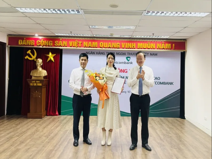 Phó Tổng Giám đốc Vietcombank Lê Quang Vinh (bên phải) trao quyết định và ông Nguyễn Trung Hà - Chủ tịch HĐTV VCBL (bên trái) tặng hoa chúc mừng bà Nguyễn Ngọc Trâm - tân Thành viên HĐTV VCBL.