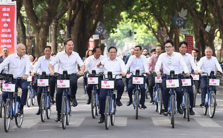 Thủ tướng Phạm Minh Chính cùng Thủ tướng Hà Lan Mark Rutte đạp xe trên đường phố Hà Nội. (Ảnh: Văn Điệp/TTXVN)