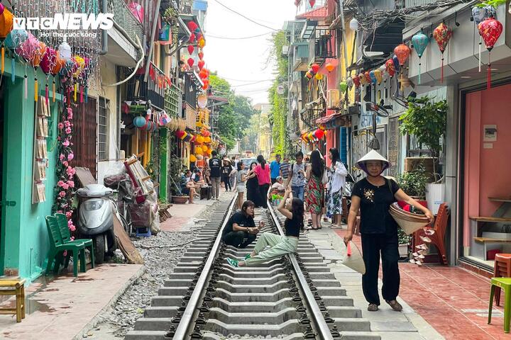 Bất chấp nguy hiểm, du khách vẫn chụp hình tại khu phố cà phê đường tàu mới.