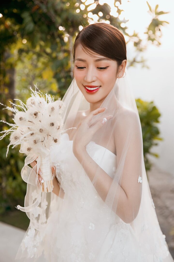 Cô dâu Puka lựa chọn 2 chiếc đầm cưới màu trắng tinh khôi. Một chiếc có dáng xòe bồng bềnh với khăn voan đính hoa trắng cầu kỳ được diện trong lúc cử hành lễ cưới.