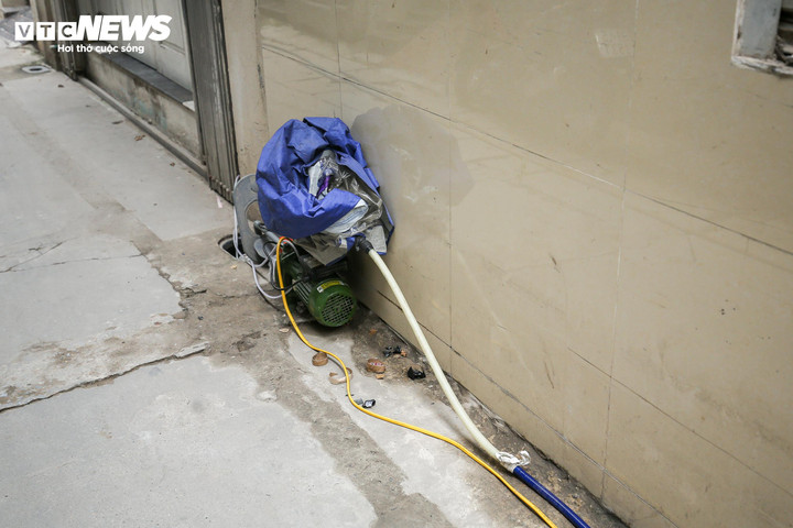 Những máy bơm tăng áp đặt tại con ngõ 98/20 đường Tân Triều nhằm đẩy nước đến từng hộ gia đình. (Ảnh: Khổng Chí)