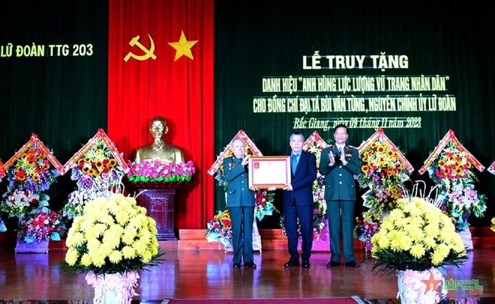 Thiếu tướng Trần Danh Khải trao truy tặng danh hiệu Anh hùng Lực lượng vũ trang nhân dân của Chủ tịch nước đối với Đại tá Bùi Văn Tùng cho đại diện gia đình tại buổi lễ.