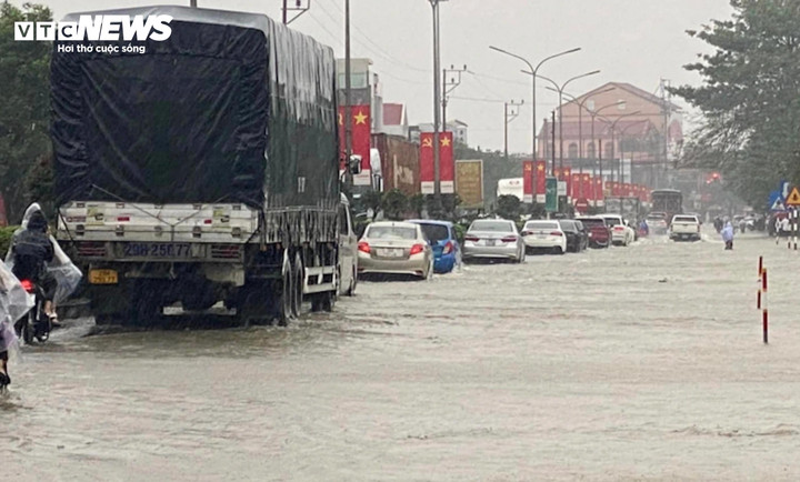 Mưa lớn khiến Quốc lộ 1A đoạn qua thị trấn Nghèn (huyện Can Lộc, tỉnh Hà Tĩnh) ngập sâu trong nước khiến các phương tiện lưu thông khó khăn. (Ảnh: V.N)