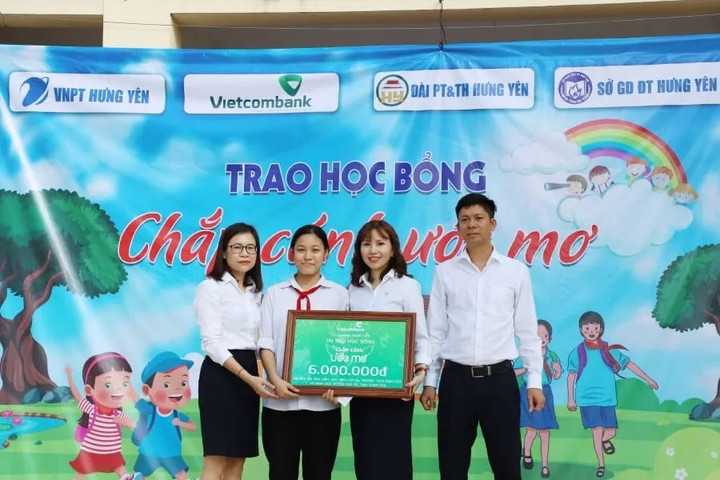 Đại diện Vietcombank Hưng Yên (thứ 2 từ trái sang) trao học bổng cho em Đào Thị Ánh Linh.