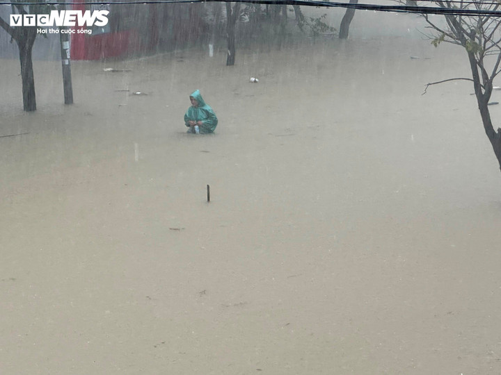 Người dân Thừa Thiên - Huế bì bõm trong dòng nước lũ đang dâng cao.