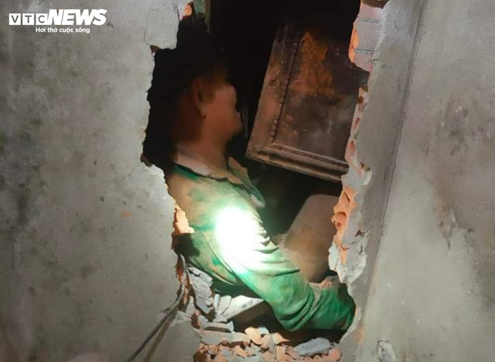 Lực lượng chức năng đục tường giải cứu thành công vợ chồng ông Minh bị đất đá vùi lấp trong nhà. (Ảnh: CACC)