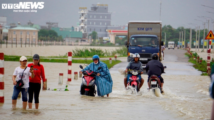 Các đường tỉnh lộ huyện Tuy Phước tuy đã ngập nhưng một số người dân vẫn bất chấp di chuyển qua dòng nước lũ.