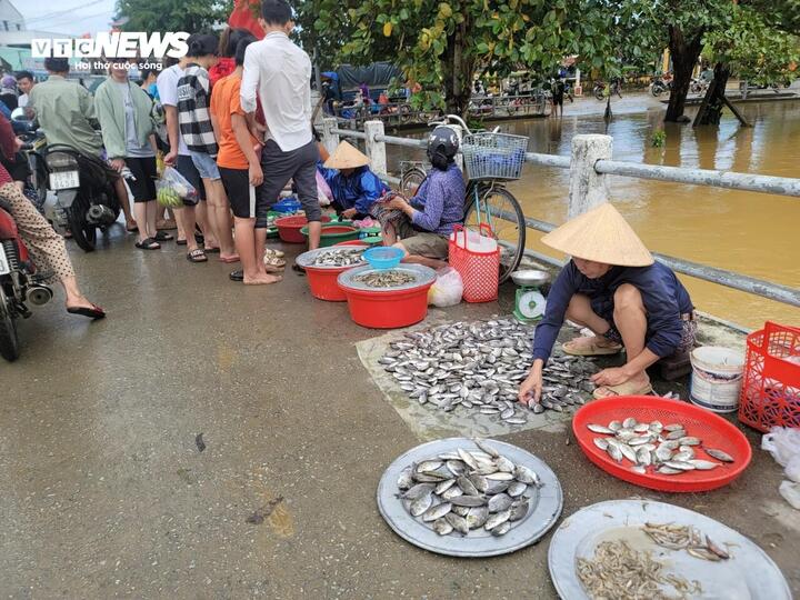 Chợ Nọ (xã Phú Dương) đầy rác và bùn lầy sau khi nước rút khiến người dân phải kéo lên cầu họp chợ