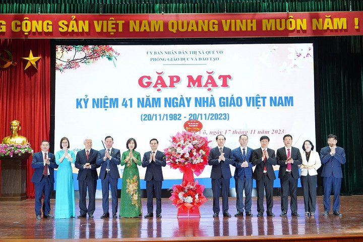 Ông Lê Hồng Phúc - Tỉnh ủy viên, Bí thư Thị ủy, Chủ tịch HĐND thị xã Quế Võ cùng các đồng chí lãnh đạo thị xã tặng hoa chúc mừng Phòng GD&ĐT.