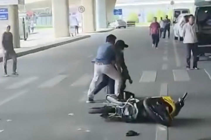 Đối tượng phi xe máy vào sân bay Tân Sơn Nhất rồi bị vây bắt. Ảnh cắt từ clip.