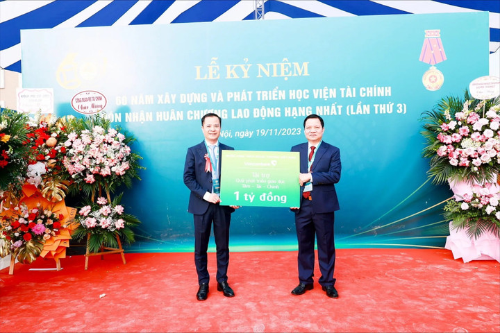 Ông Lê Hoàng Tùng - Phó Tổng Giám đốc Vietcombank (bên trái) thay mặt Ban Lãnh đạo Vietcombank trao tặng 1 tỷ đồng cho đại diện Nhà trường để đóng góp vào Quỹ phát triển giáo dục Tâm - Tài - Chính.