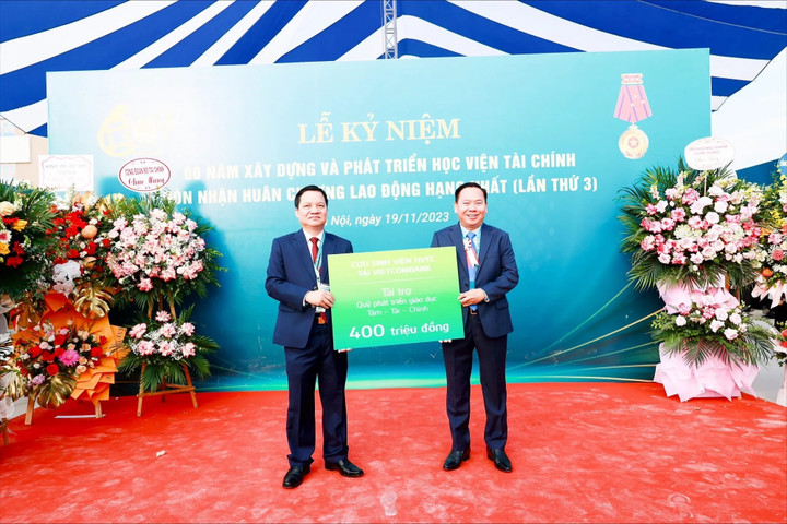 Ông Lại Hữu Phước - Trưởng Ban kiểm soát Vietcombank thay mặt cho các cựu học viên Học viện tài chính tại Vietcombank (bên phải) đóng góp 400 triệu đồng cho Quỹ Tâm - Tài - Chính.