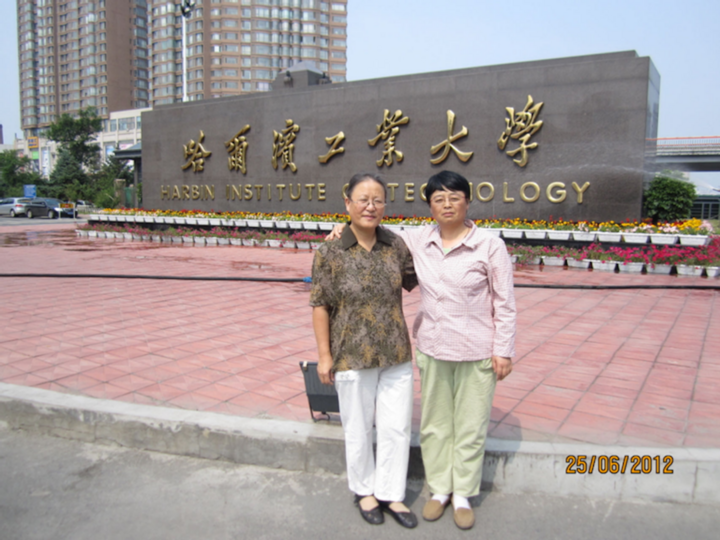 Cô La Quắc Thụy (đầu tiên từ trái sang) và cô Dương Lệ Na chụp ảnh lưu niệm trước cổng trường. (Ảnh: QQ News)