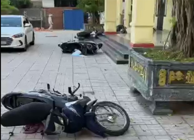 Hàng loạt xe máy dựng ở sân trụ sở UBND xã An Đồng bị đạp đổ. (Ảnh cắt từ clip).