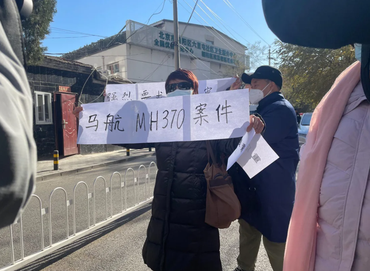 Thân nhân của hành khách trên chuyến bay MH370 trước tòa án ở quận Triều Dương, Bắc Kinh ngày 27/11. (Ảnh: CNN)