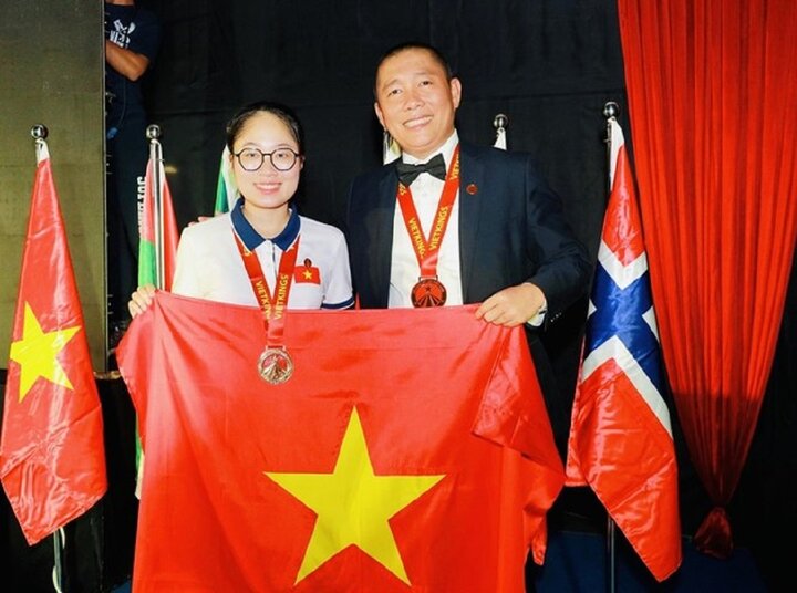 Đặng Ngọc Phương Trinh (bên phải) và tấm huy chương vàng tại cuộc thi Siêu trí nhớ thế giới 2023