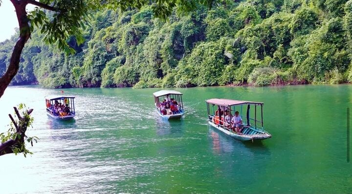 Du khách tham quan hồ Ba Bể bị mê hoặc bởi mặt nước trong xanh và cảnh núi non hai bên hồ.