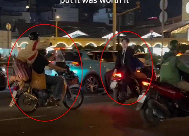 L. lái xe máy chở theo sau M. đứng trên yên xe để quay TikTok. (Ảnh: Cắt từ clip)