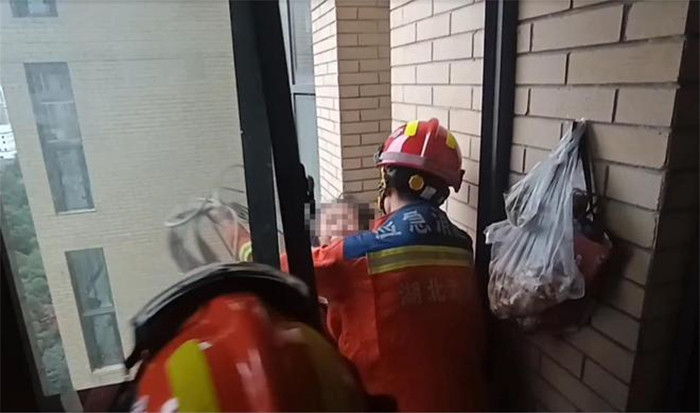 Người phụ nữ được cảnh sát cứu hỏa tới giải cứu.