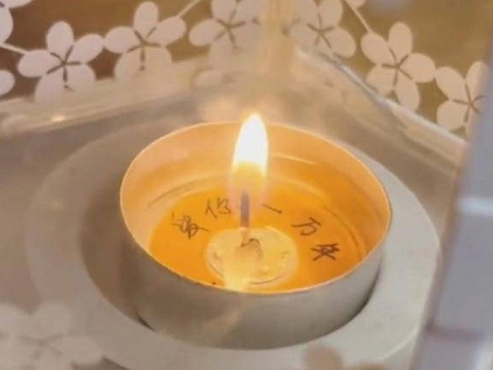 Dòng chữ "yêu em một vạn năm" trong cây nến hiện lên khiến hai vợ chồng bất ngờ.