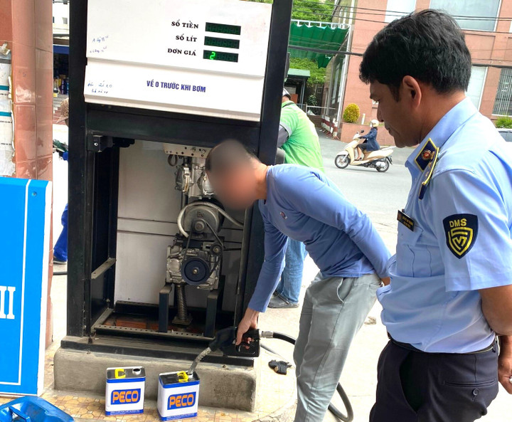 Lấy mẫu xăng kiểm định chất lượng.