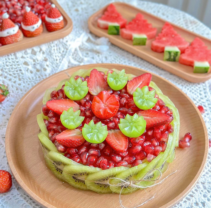 Chiếc bánh kem được chị dùng dưa hấu làm cốt bánh. Chị Thủy cắt miếng dưa hấu thành hình tròn, tiếp đó cắt kiwi thành lát mỏng vừa phải rồi xếp xung quanh, sau đó rải hạt lựu lên trên phủ kín phần dưa hấu và trang trí thêm bằng nho, dâu tây. (Ảnh: Cao Thanh Thủy)