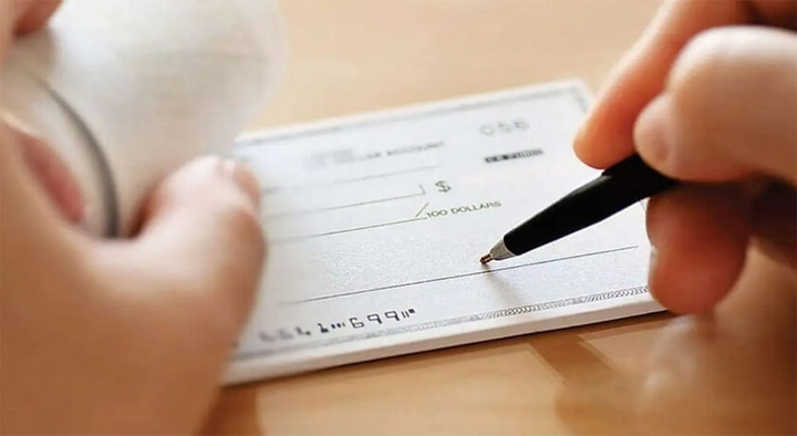 Rút tiền mặt từ tài khoản doanh nghiệp bằng séc hoặc giấy rút tiền. (Ảnh minh họa)